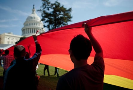 people holding a big Pride flag