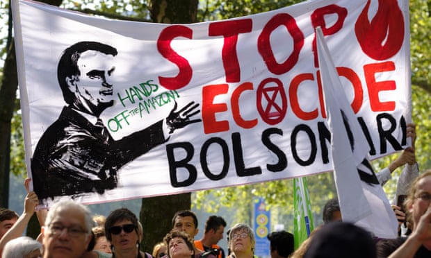 Activists hold up a banner of Jair Bolsonaro as they gather in front of the Brazilian embassy during a demonstration in Brussels, Belgium