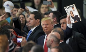Trump holds up the March 1990 issue of Playboy with him on the cover as he works the rope line after a campaign rally in Farmington, New Hampshire.