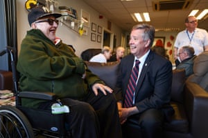 The SNP’s deputy leader, Keith Brown, in tie and jacket, talks to the second world war veteran Terry Webb wearing a cap and green jacket