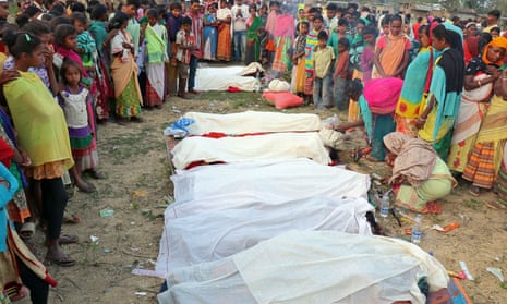 People gather around the bodies of tea plantation workers who died after drinking bootleg liquor in Golaghat, in the northeastern state of Assam, India, on Friday. 