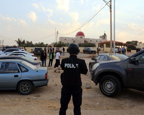 A police officer stands guard near a church in Karak, Jordan, after a shooting