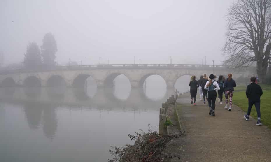 People exercising on the foggy Thames Path in Maidenhead, Buckinghamshire.