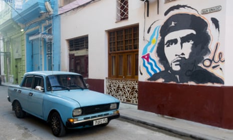 an old car next to a Che Guevara mural in havana, Cuba