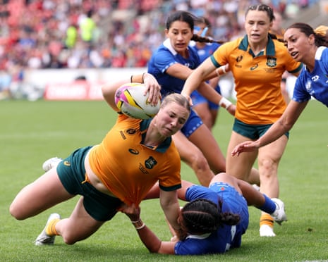 Caitlyn Halse of Australia breaks past Lutia Col Aumua of Samoa as she dives in to score her team’s third try.