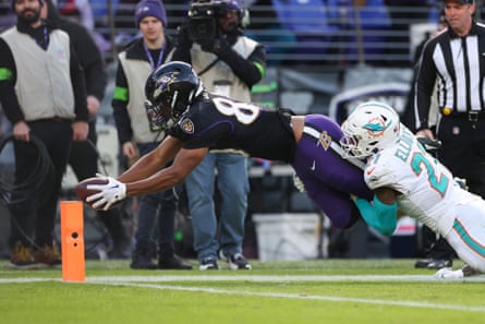 Isaiah Likely of the Baltimore Ravens scores a touchdown past DeShon Elliott of the Miami Dolphins during the second quarter of Sunday’s game at M&T Bank Stadium.