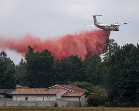 A plane drops fire retardant as efforts to battle wildfires continue amid drought conditions following a heatwave and water shortages across much of France, in Marcheprime, Gironde department, France.
