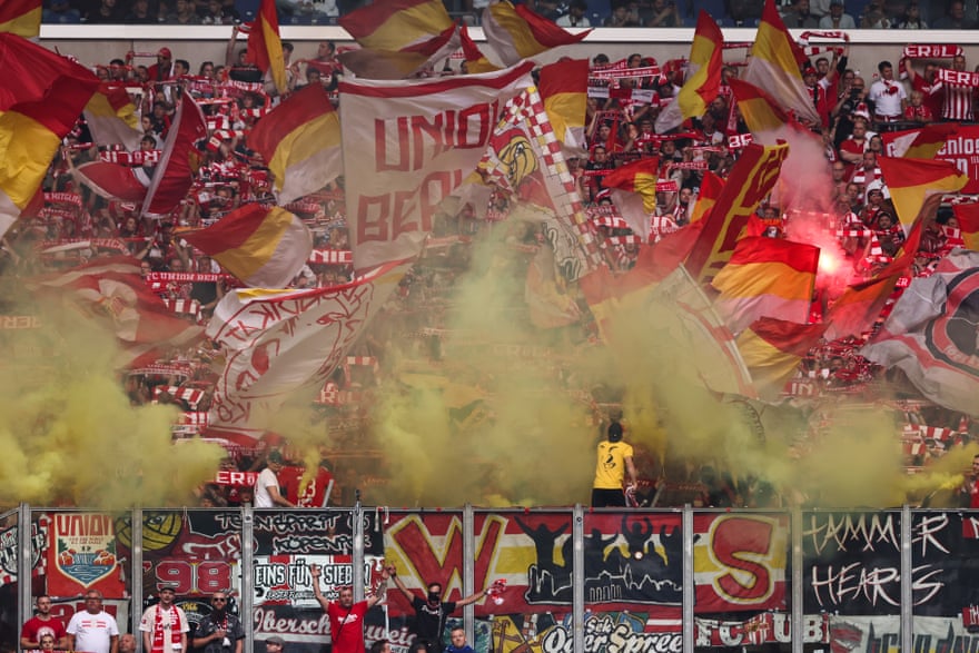 Union Berlin fans wave flags and set off smoke bombs in the stands