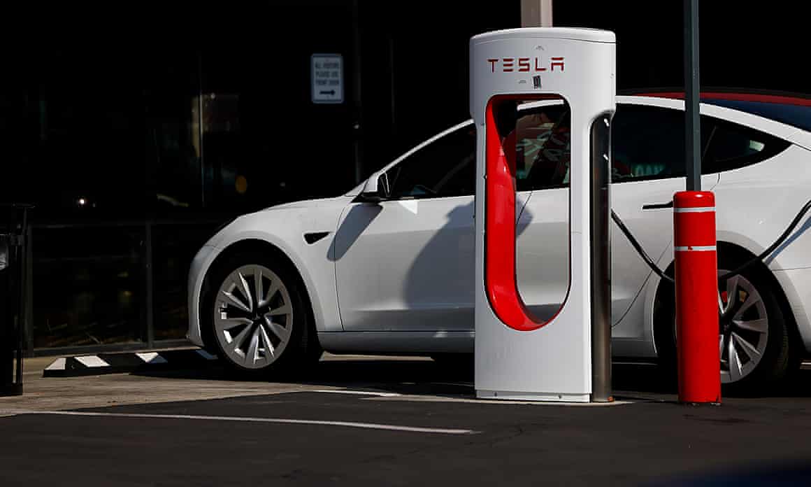 A Tesla is connected to a charger