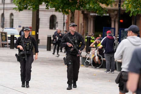 Two armed police officers patrol the streets in central manchester.