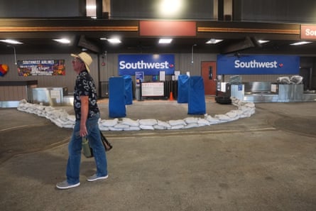 Curved line of white sandbags in front of Southwest desk at an airport.