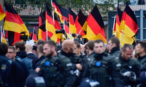 Supporters of the AfD party wave German flags as they walk behind police during a demonstration in Chemnitz, Germany, October 2020.