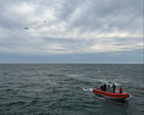 Coast Guard crew in a rescue boat and aircraft search the sea off Nantucket for a missing plane
