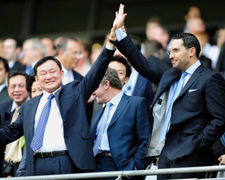 The outgoing Manchester City chair, Thaksin Shinawatra, holds up the hand of his imminent successor, Khaldoon Al Mubarak, before a City home Premier League game in 2008.