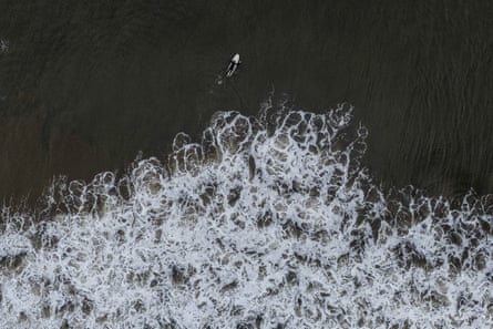 An aerial view of a surfer in a dark choppy sea
