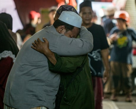 Relatives of missing students in Indonesia school collapse mourn as search and rescue operations continue.