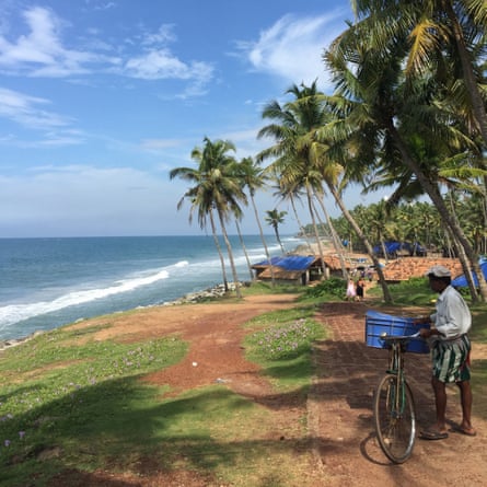 A man wheels a bike near Varkala beach.