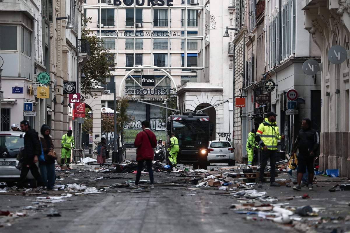 Municipal workers clean a street covered on debris a day after nationwide protests against the "high cost of living", in Marseille on Sunday.