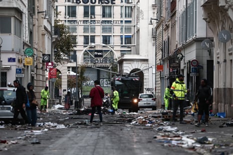 Municipal workers clean a street covered on debris a day after nationwide protests against the "high cost of living", in Marseille on Sunday.