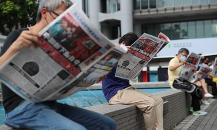 People read the Apple Daily newspaper at Status Square in Hong Kong as part of a silent protest