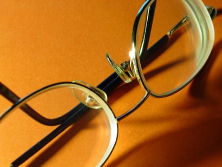 A pair of eyeglasses against an orange background