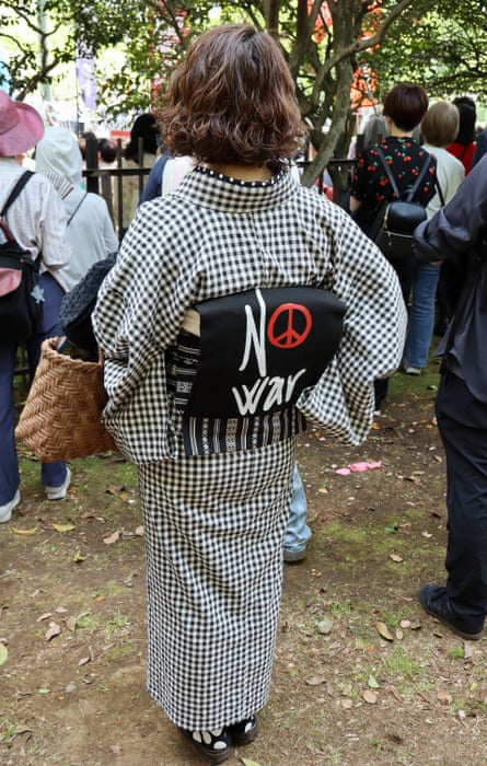 A woman in kimono with an obi belt carrying an anti-war message during a demonstration in support of Japan’s pacifist constitution outside the country’s parliament in Tokyo on 19 April.