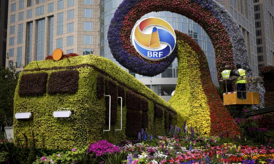 Workers on a platform install flowers on a decoration in a shape of a train for promoting the upcoming Belt and Road Forum in Beijing 