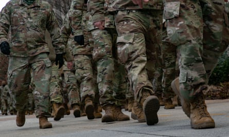 National guard troops march towards the Capitol on inauguration day, 20 January. The armed forces are now having to confront the prospect of far-right extremism within their own ranks.