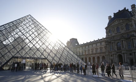 Visitors queue for the Louvre museum in Paris.