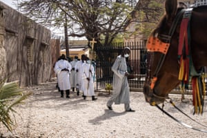 An altar boy carries a cross at the start of Easter mass in Fadiouth
