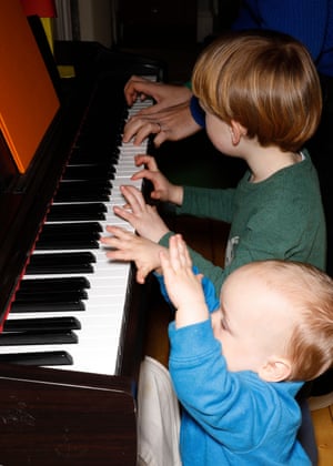 The boys try to play the piano.