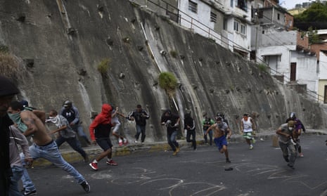 Anti-government demonstrators run during clashes with police and troops in the surroundings of a national guard command post in Cotiza, in northern Caracas, on Monday.