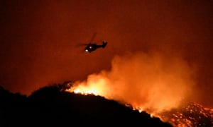 A firefighting helicopter over the Getty Fire north-west of downtown Los Angeles last night