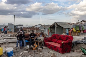 Family members sit on sofas in a demolished area of Mukuru Kwa Njenga