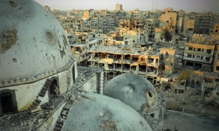 The battle-scarred Khalid ibn al-Walid mosque looms in front of the devastated city of Homs.