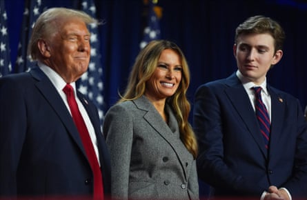 Donald Trump, Melania and Barron on stage together smiling.