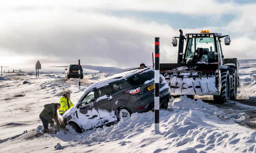 People work to pull a car back on to the road on the Buttertubs Pass in North Yorkshire.