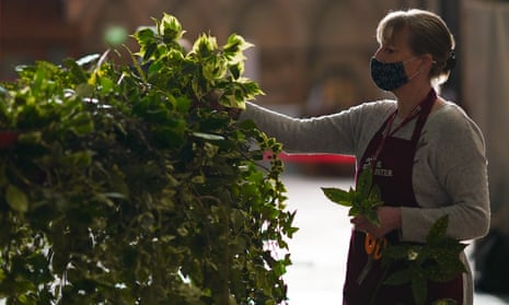 Volunteer flower arranger Mandy Barker makes finishing touches to ivy on the advent wreath before it is raised into position at York Minster this year.