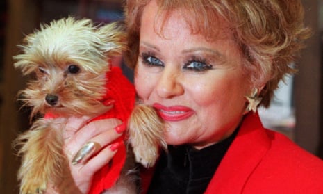 Tammy Faye Messner holding a small dog.
