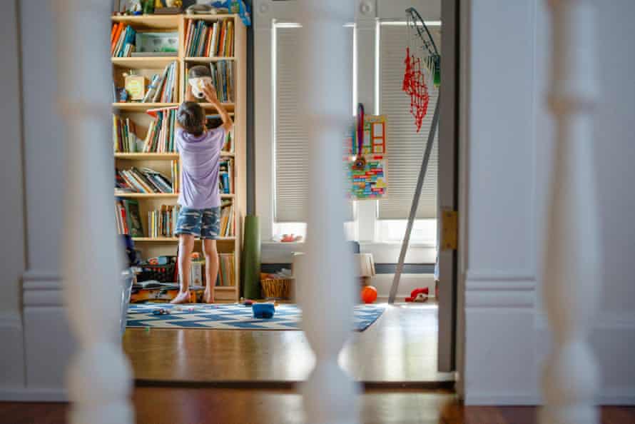 A child reaching for a toy on a high bookshelf (staged photo).
