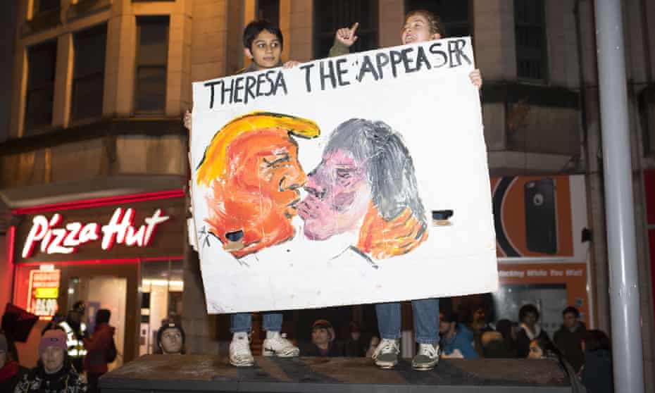 Two people hold up a banner saying 'Theresa the appeaser'