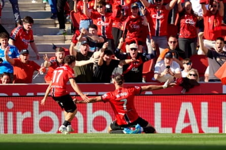 Vedat Muriqi slides in front of the Mallorca supporters after his winner in added time.
