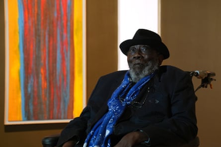 Artist Frank Bowling in front of a painting