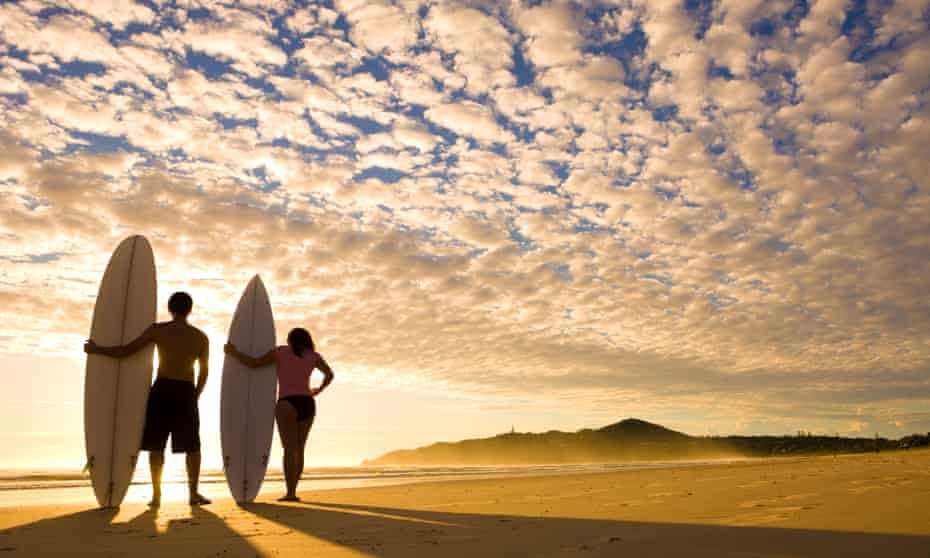Two surfers at sunrise about to go out