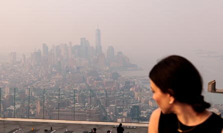 A woman looks at the Manhattan skyline engulfed in haze on 7 June.