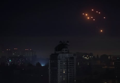 Explosions are seen in the night sky from Kyiv as Ukrainian servicemen fire towards drones during a Russian drone strike.