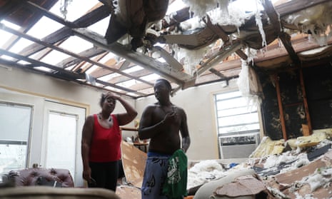 Latasha Myles and Howard Anderson stand in their living room where they were sitting when the roof blew off around 2:30am as Hurricane Laura passed through the area on August 27, 2020 in Lake Charles, Louisiana.