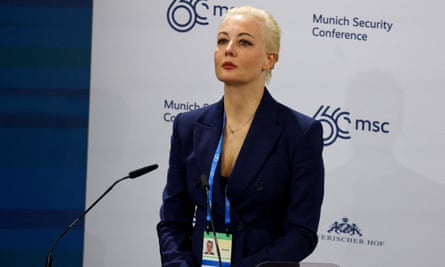 Yulia Navalnaya addressed the Munich security conference: she is wearing a dark blue jacket and top, with red lipstick, and has her blond hair scraped back from her face; there are tears in her eyes