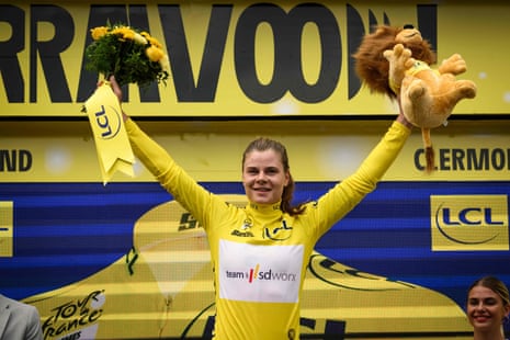 SD Worx's Lotte Kopecky celebrates on the podium as she wears the overall leader's yellow jersey after winning the first stage of the Tour de France Femmes 2023.