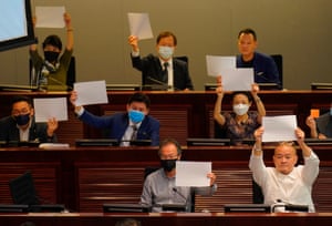Pro-democracy lawmakers raise white papers to protest during a meeting to discuss the new national security law at the Legislative Council in Hong Kong.